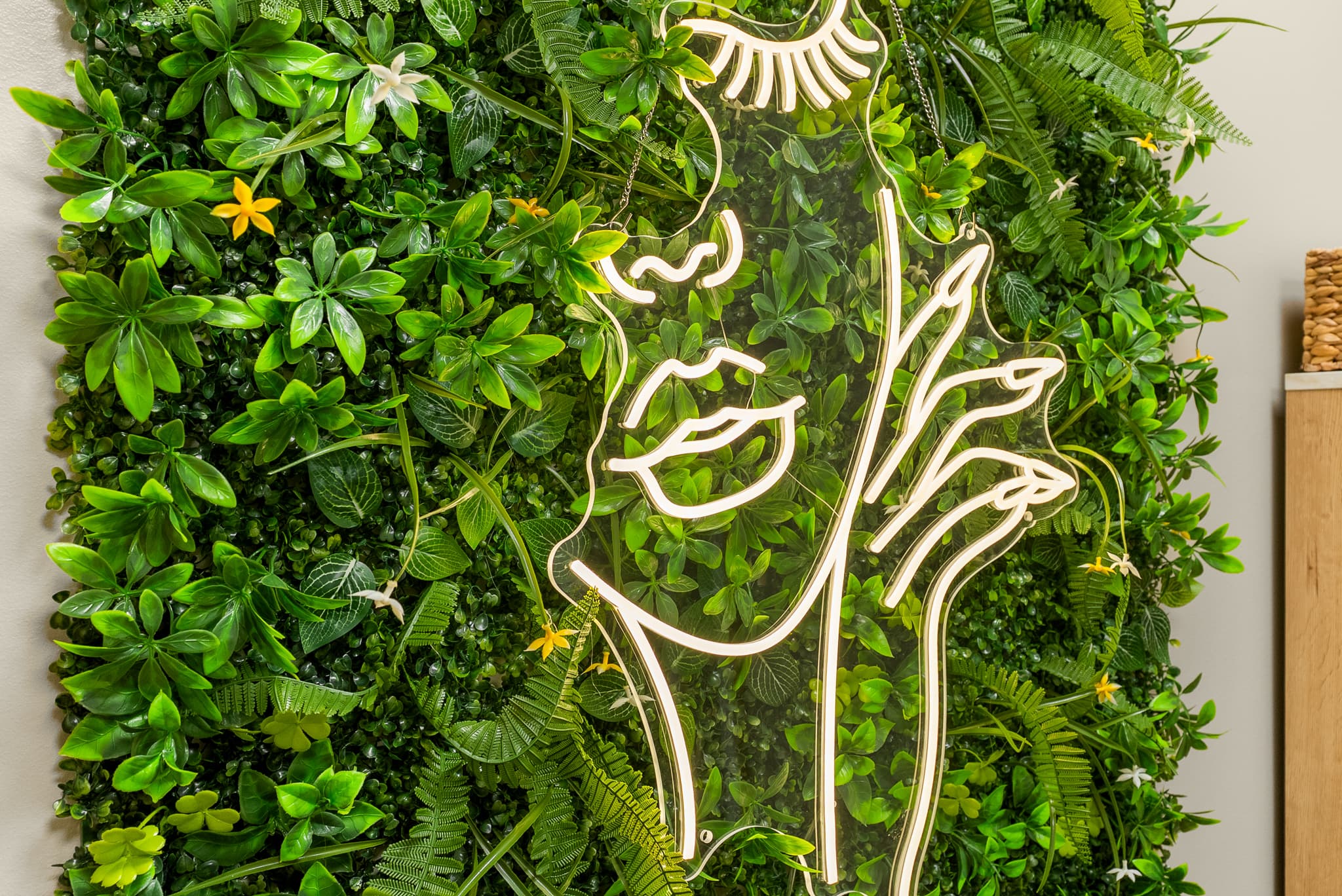 The signature neon greenery wall in the aesthetics treatment room